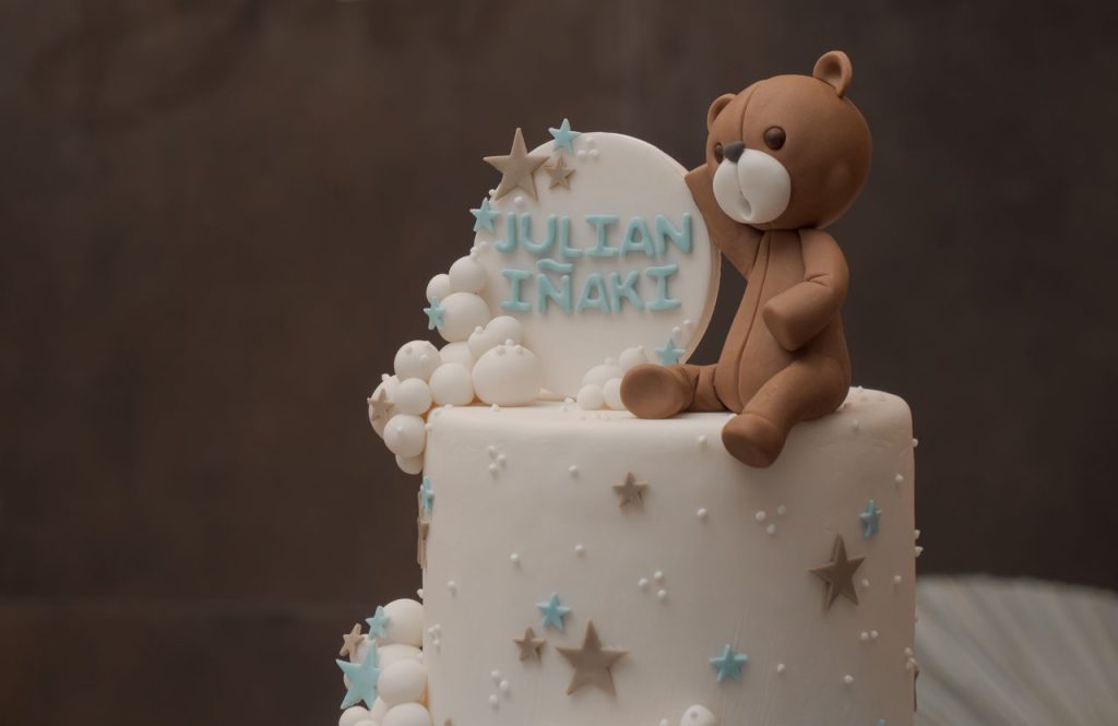 Cute teddy bear themed cake featuring personalized fondant topper, perfect for celebrations.