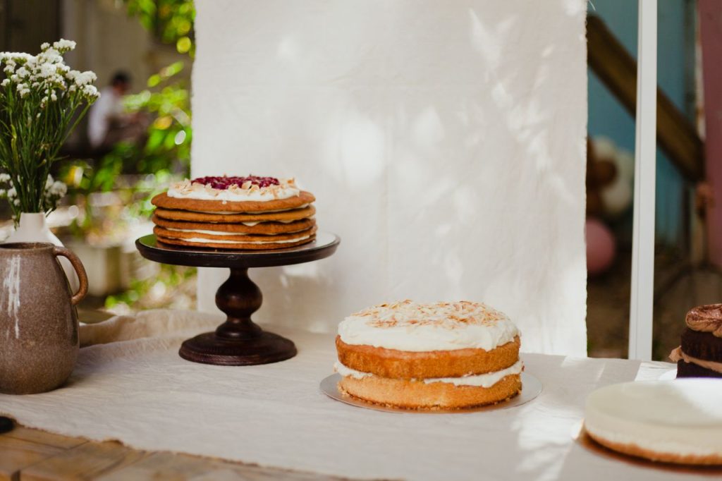 A selection of beautifully presented layer cakes on a table with natural lighting. Ideal for food photography and dessert enthusiasts.